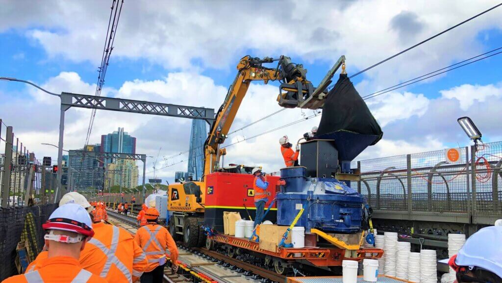 Hoisting DURA premix into the mixer through a funnel.