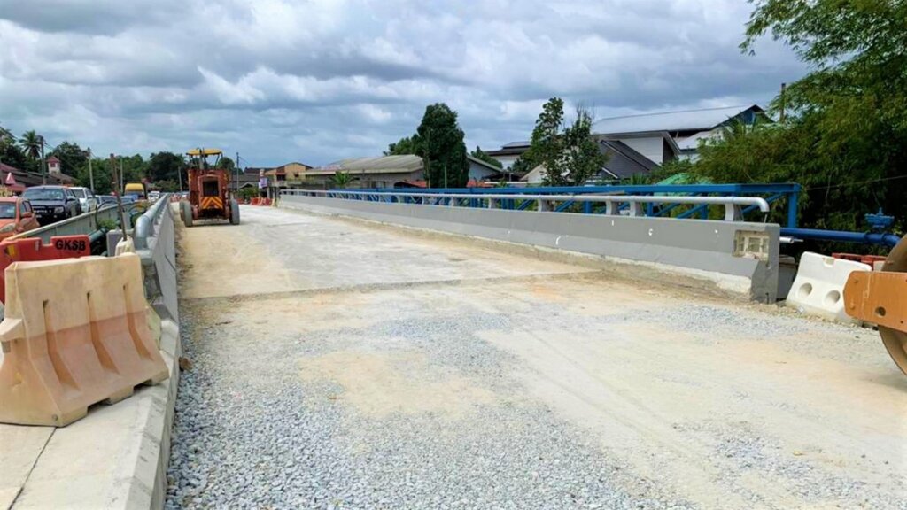 Completion of bridge part, left approach road, and wearing surface.