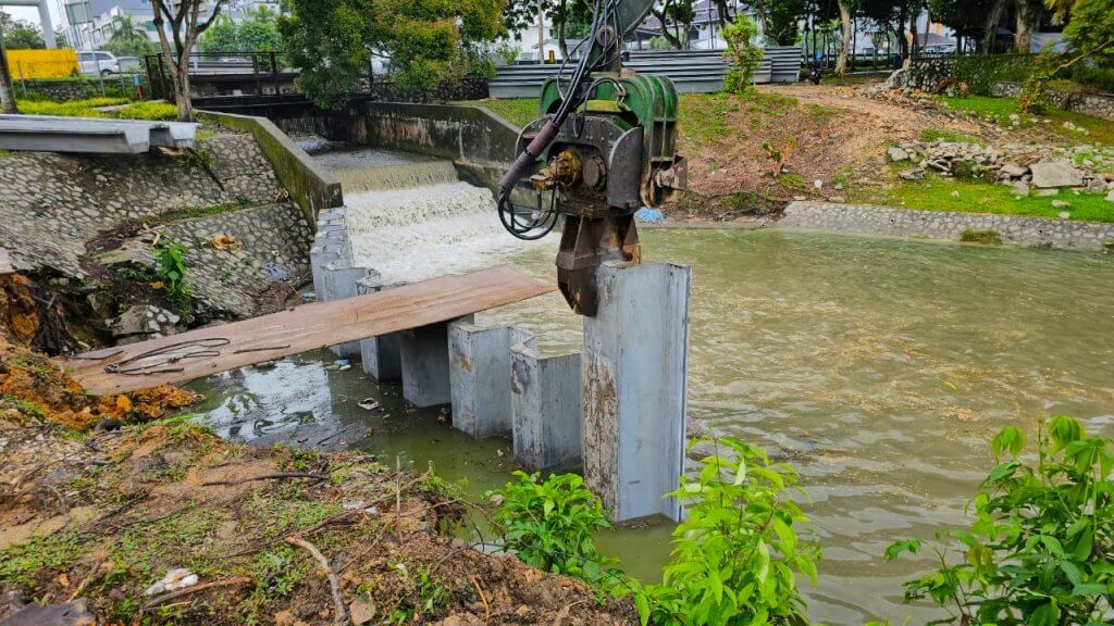 Press reinforced DURA sheet pile into ground by using piling machinery.