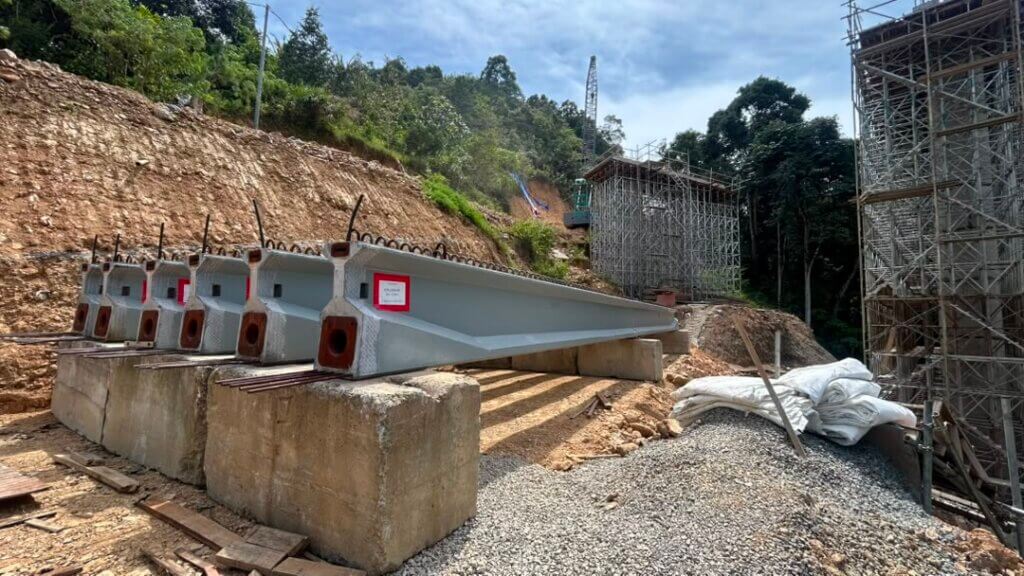 Precast prestressed concrete beams are temporarily stored on concrete support blocks, pending post-tensioning works.