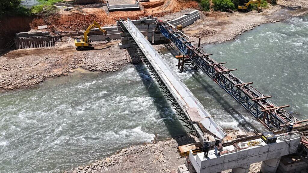 The first U beam has been successfully installed, aligned, and seated onto the reinforced concrete abutments.