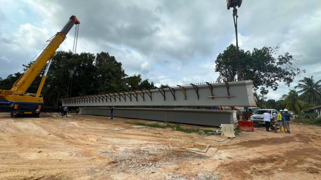 Beam lifting and placement onto abutments in progress.