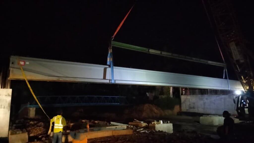 Lifting the entire 30-metre beam onto the abutments.