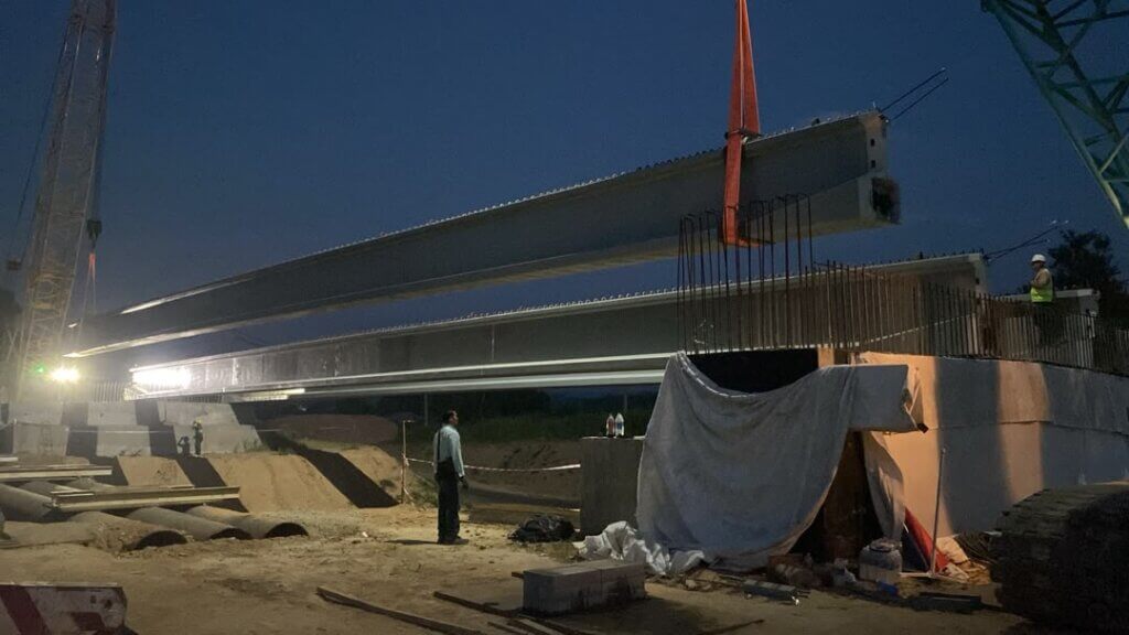 Bridge 2 : Precast concrete bridge girders are being lifted and positioned onto the bridge supportsabutments using a mobile crane.