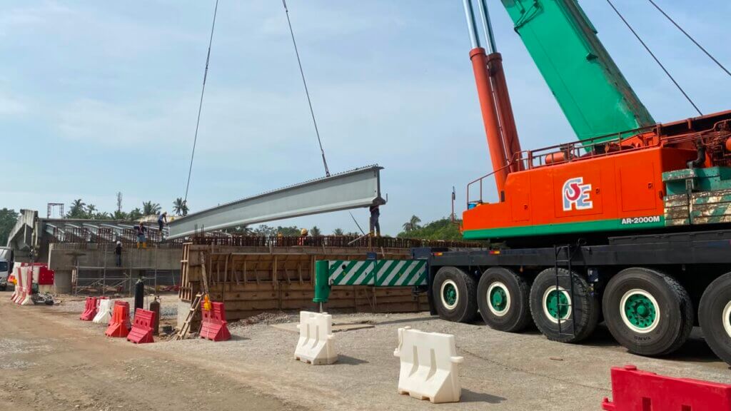 Beam is being lifted into position and lowered onto the abutments.
