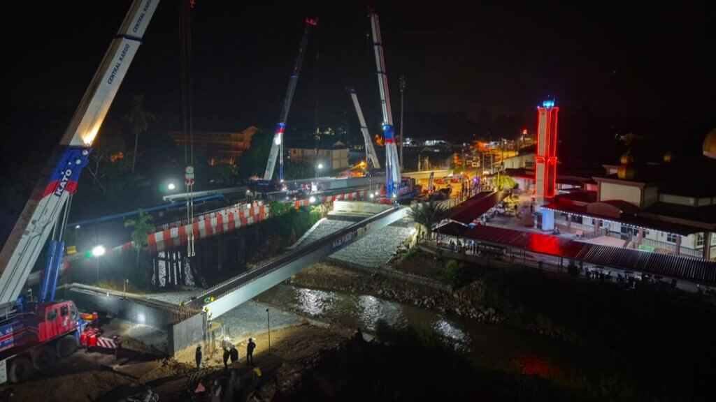 The first bridge beam has been lifted into position and seated on the abutments